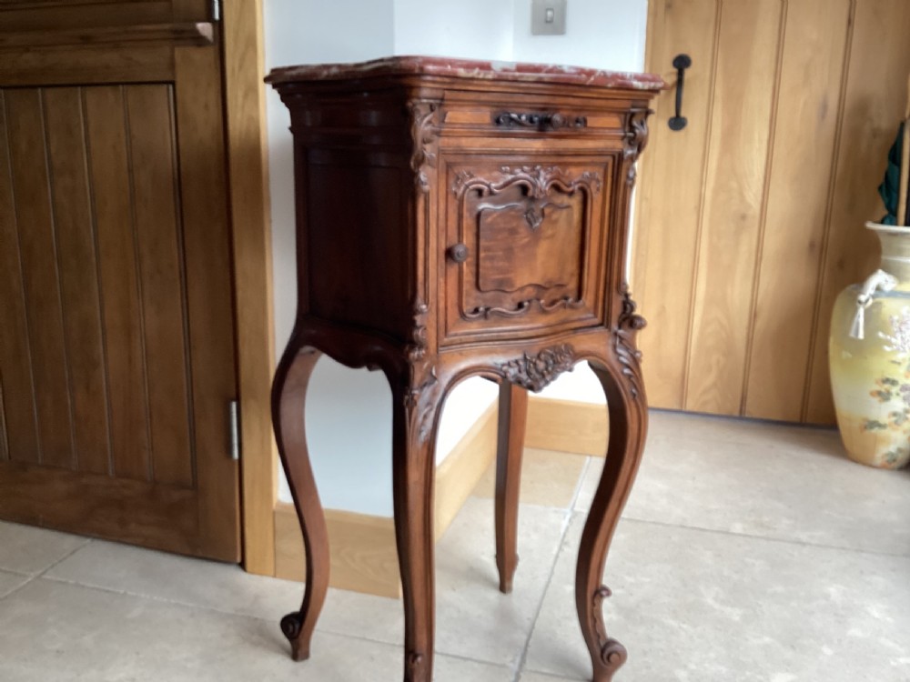 An antique French Rococo style carved walnut pot cupboard with a contoured red marble top and slender cabriole legs. View VIII