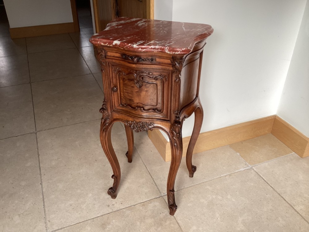 An antique French Rococo style carved walnut pot cupboard with a contoured red marble top and slender cabriole legs. View IX