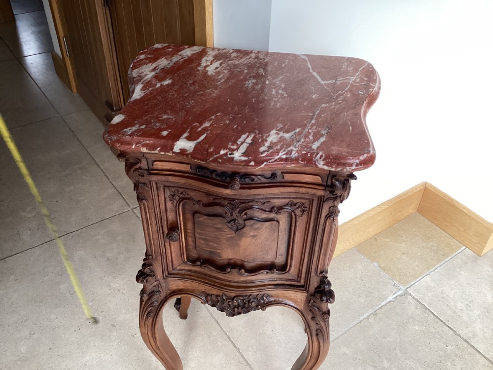 An antique French Rococo style carved walnut pot cupboard with a contoured red marble top and slender cabriole legs. View XI