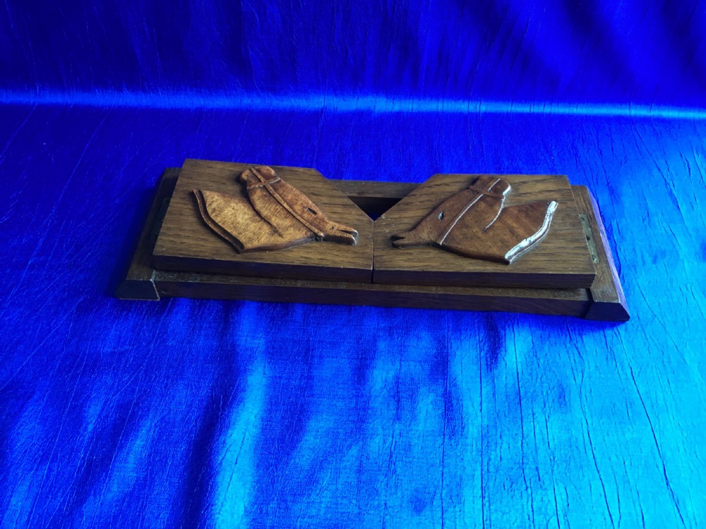 A solid oak Art Deco desktop book trough featuring angled side supports with carved horse silhouettes connected by twin horizontal rails. View III