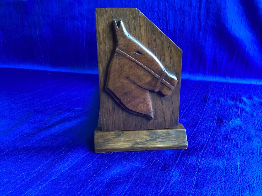 A solid oak Art Deco desktop book trough featuring angled side supports with carved horse silhouettes connected by twin horizontal rails. View IV