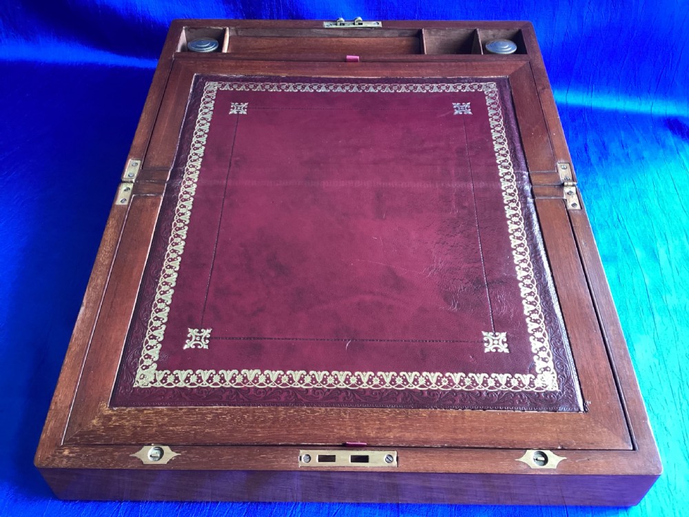 A rectangular dark walnut wooden writing slope featuring stylised floral marquetry inlay across the top lid and a key with a pink tassel in the front lock. View IV