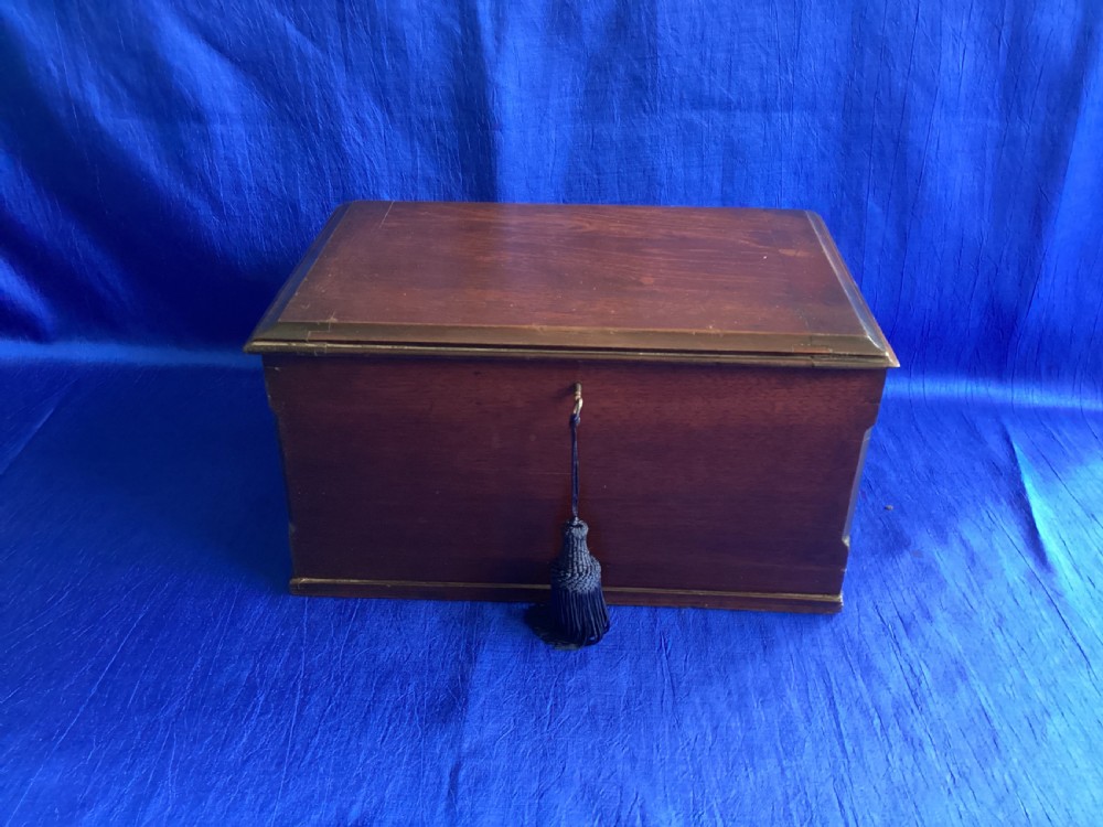 A rectangular dark mahogany storage box featuring a hinged lid with moulded edges and a central keyhole. View III