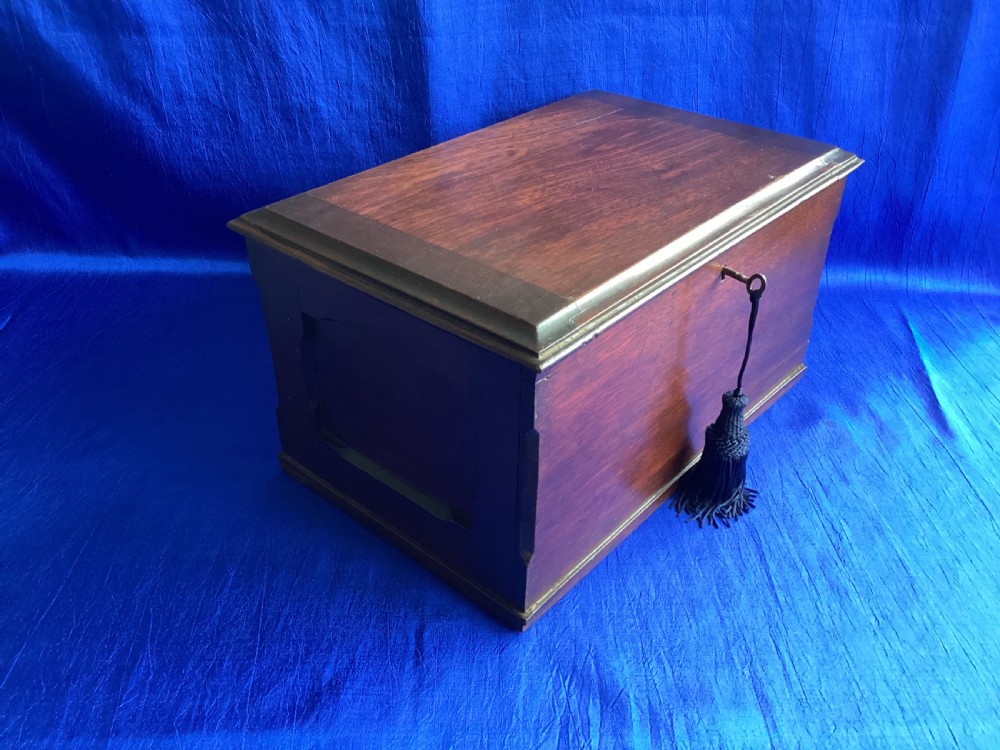 A rectangular dark mahogany storage box featuring a hinged lid with moulded edges and a central keyhole. View V
