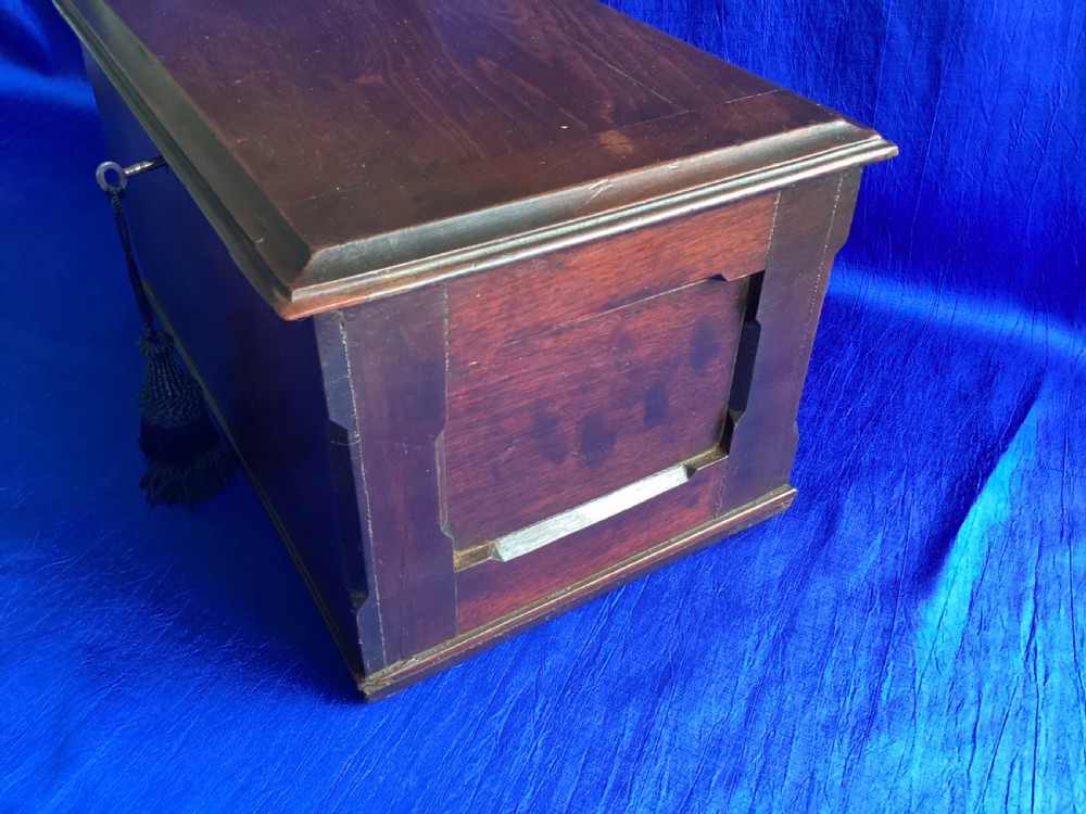 A rectangular dark mahogany storage box featuring a hinged lid with moulded edges and a central keyhole. View VI
