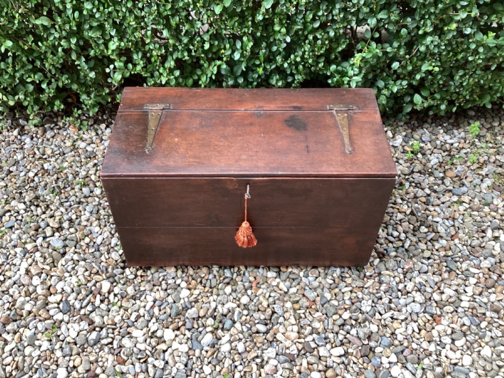 A rectangular dark mahogany wooden bible box featuring brass strap hinges on top and a keyhole with a decorative tassel on the front.