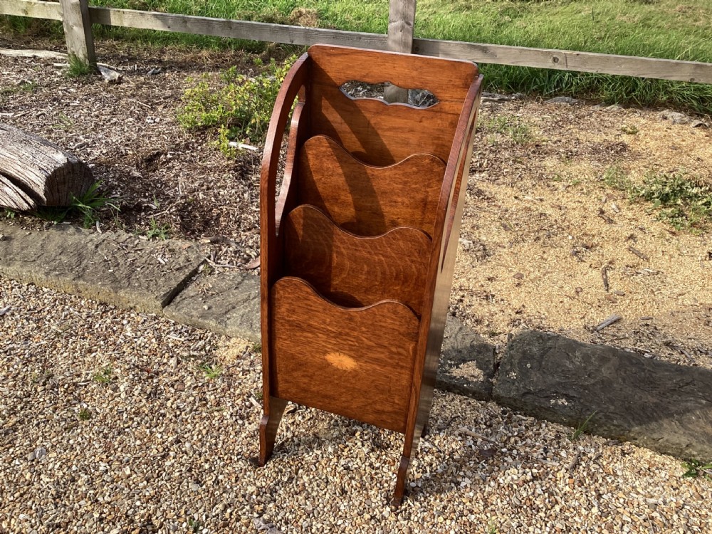 A floor-standing Edwardian oak magazine rack featuring three tiered sections, an integrated top handle aperture, and an oval marquetry shell inlay on the lower panel. View III