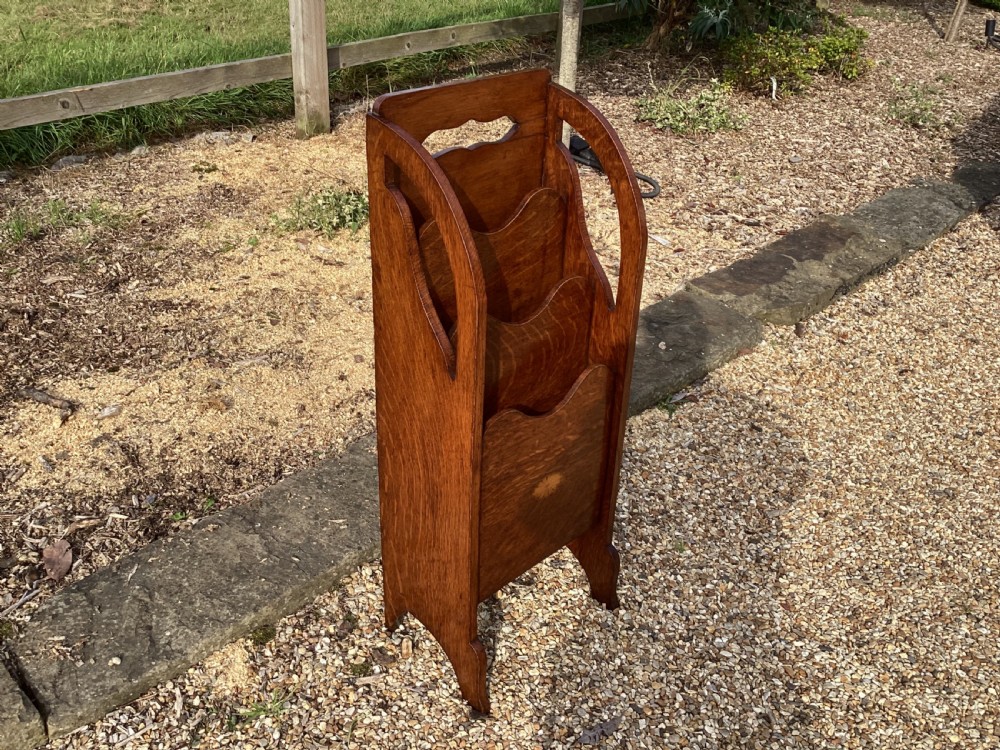 A floor-standing Edwardian oak magazine rack featuring three tiered sections, an integrated top handle aperture, and an oval marquetry shell inlay on the lower panel. View V