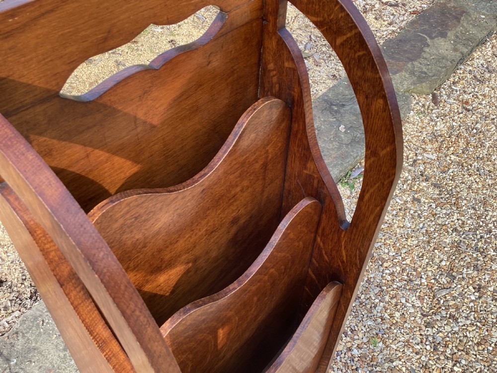 A floor-standing Edwardian oak magazine rack featuring three tiered sections, an integrated top handle aperture, and an oval marquetry shell inlay on the lower panel. View IX