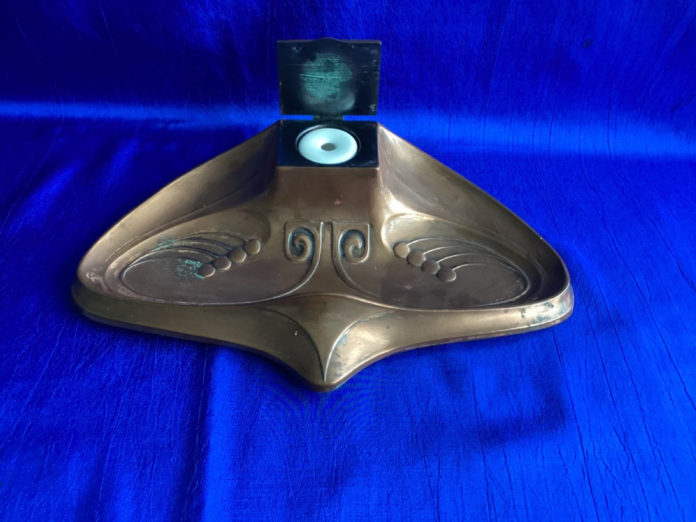 An antique Art Nouveau cast copper inkstand with a central hinged lid, contoured pen recesses, and embossed stylised botanical scrollwork. View IV