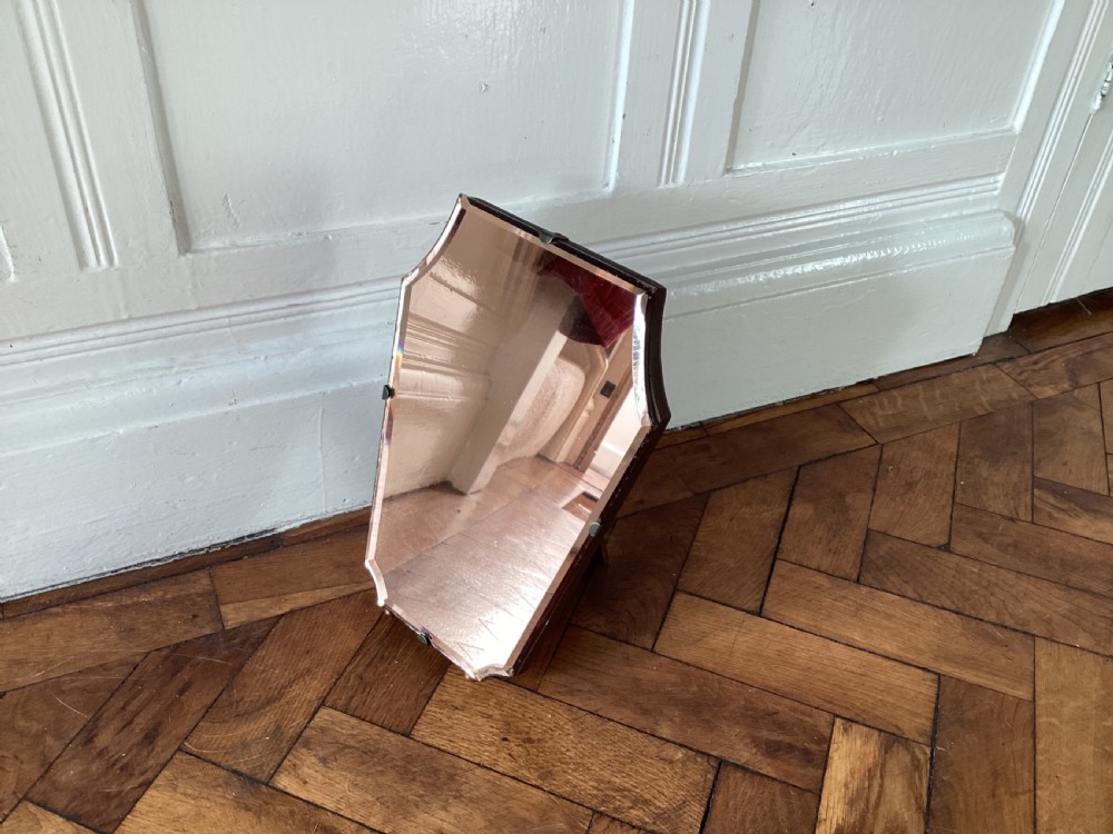 A frameless Art Deco easel vanity mirror made from peach-tinted glass with bevelled edges and chrome securing clips. View II