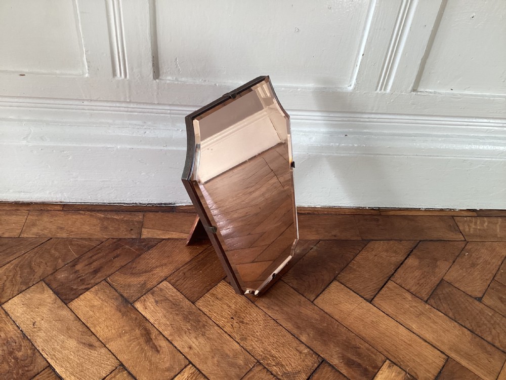 A frameless Art Deco easel vanity mirror made from peach-tinted glass with bevelled edges and chrome securing clips. View III