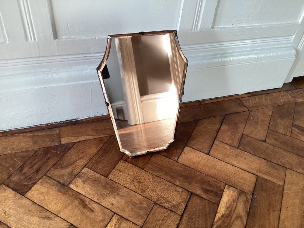 A frameless Art Deco easel vanity mirror made from peach-tinted glass with bevelled edges and chrome securing clips. View IV