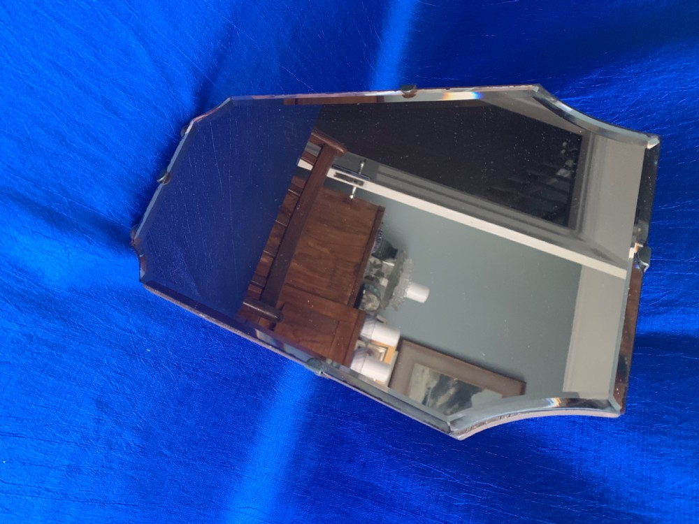 A frameless Art Deco easel vanity mirror made from peach-tinted glass with bevelled edges and chrome securing clips. View VI