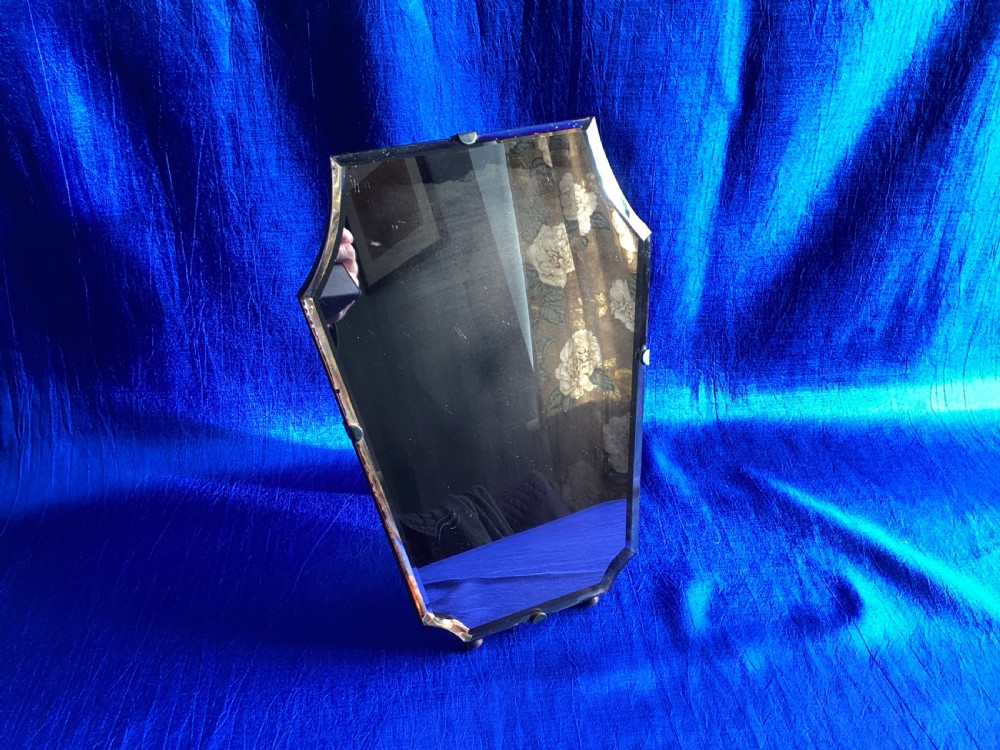A frameless Art Deco easel vanity mirror made from peach-tinted glass with bevelled edges and chrome securing clips. View VII