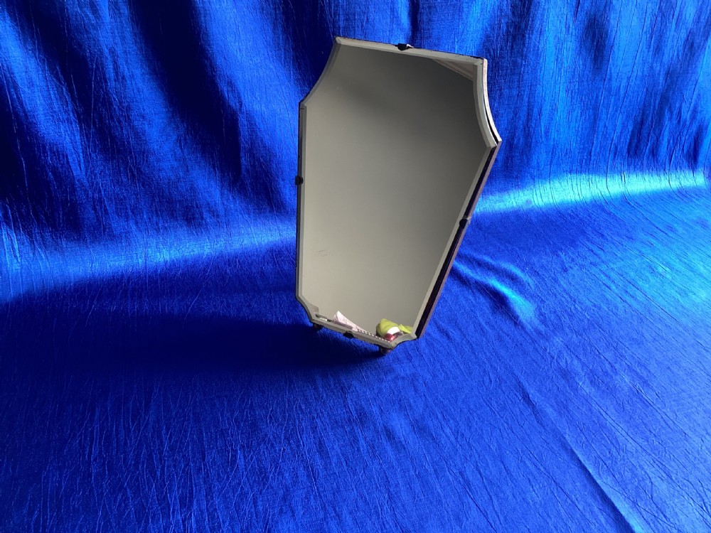 A frameless Art Deco easel vanity mirror made from peach-tinted glass with bevelled edges and chrome securing clips. View VIII