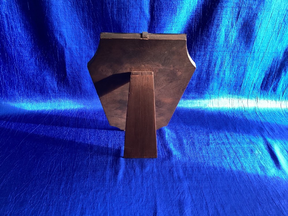 A frameless Art Deco easel vanity mirror made from peach-tinted glass with bevelled edges and chrome securing clips. View XI