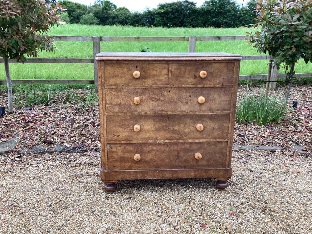 A Victorian pine chest of drawers featuring two short upper drawers over three long lower drawers, fitted with round turned wooden handles and short turned legs.