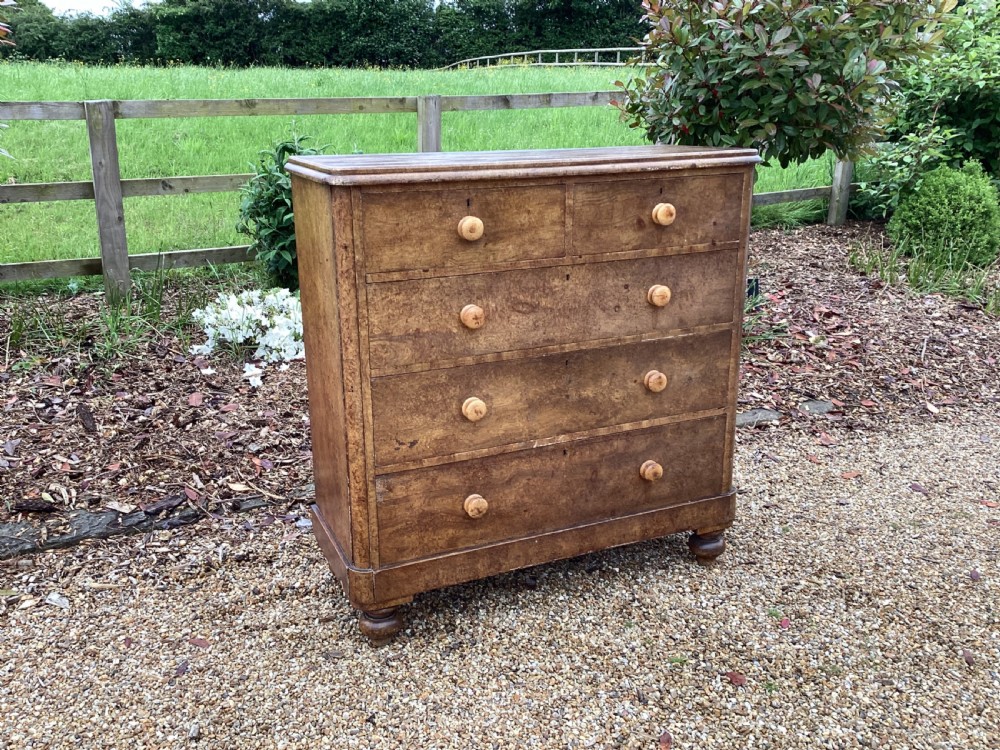 A Victorian pine chest of drawers featuring two short upper drawers over three long lower drawers, fitted with round turned wooden handles and short turned legs. View II