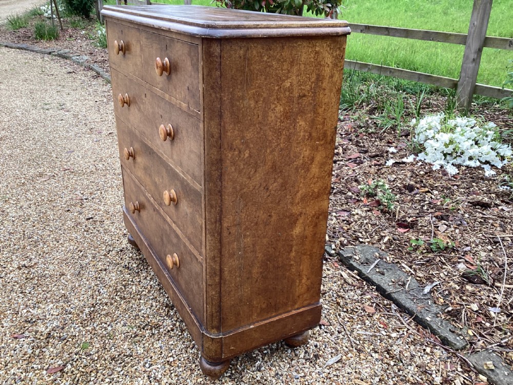 A Victorian pine chest of drawers featuring two short upper drawers over three long lower drawers, fitted with round turned wooden handles and short turned legs. View V