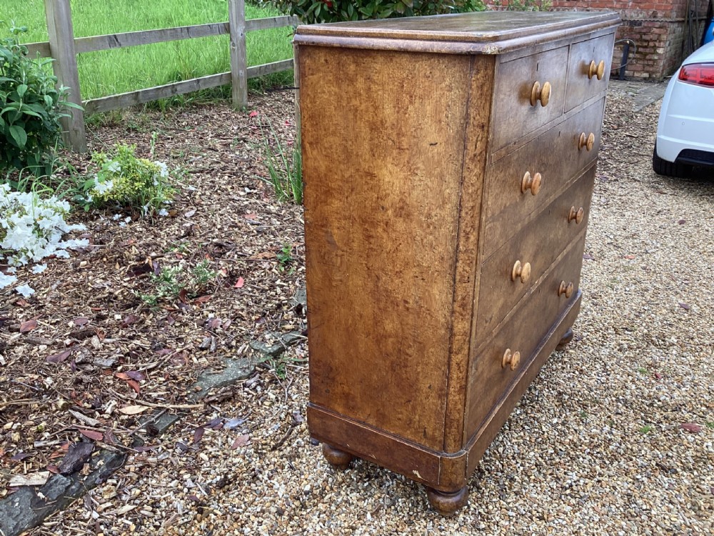 A Victorian pine chest of drawers featuring two short upper drawers over three long lower drawers, fitted with round turned wooden handles and short turned legs. View VI