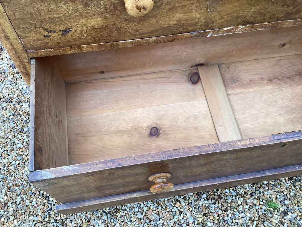 A Victorian pine chest of drawers featuring two short upper drawers over three long lower drawers, fitted with round turned wooden handles and short turned legs. View VII