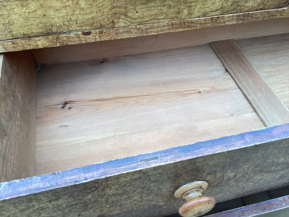 A Victorian pine chest of drawers featuring two short upper drawers over three long lower drawers, fitted with round turned wooden handles and short turned legs. View X