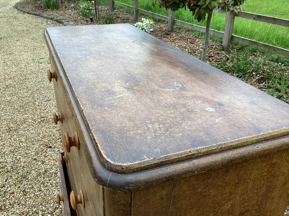A Victorian pine chest of drawers featuring two short upper drawers over three long lower drawers, fitted with round turned wooden handles and short turned legs. View XII