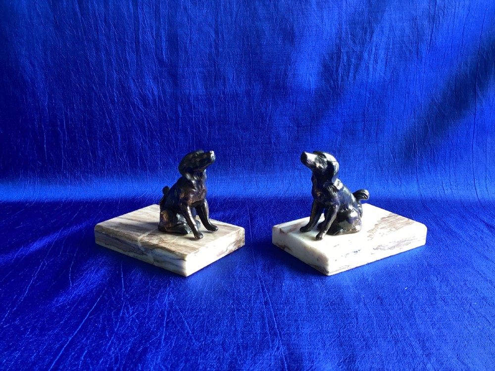 A pair of antique Art Deco bookends featuring patinated metal spaniel dogs sitting atop rectangular veined marble bases. View III