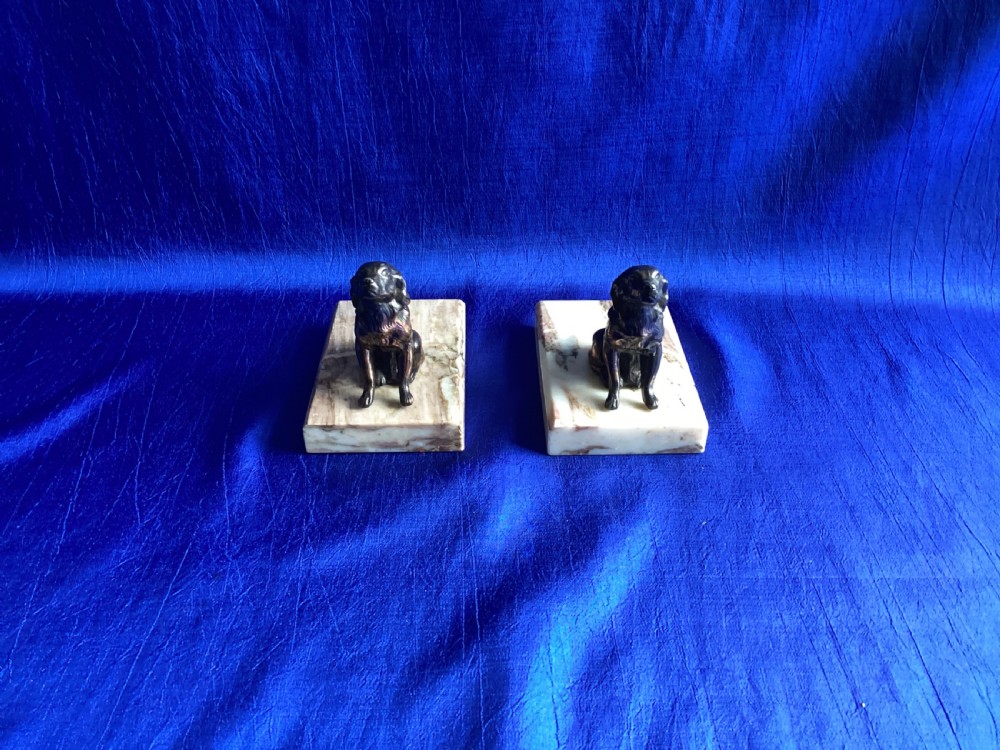 A pair of antique Art Deco bookends featuring patinated metal spaniel dogs sitting atop rectangular veined marble bases. View IV