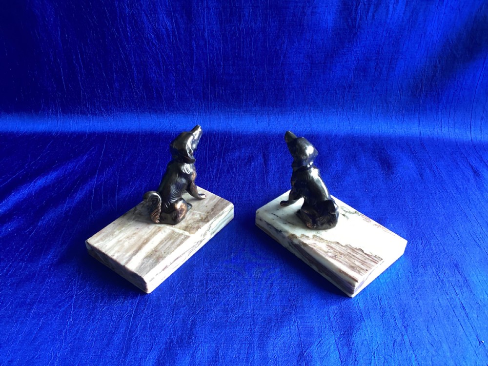 A pair of antique Art Deco bookends featuring patinated metal spaniel dogs sitting atop rectangular veined marble bases. View VII