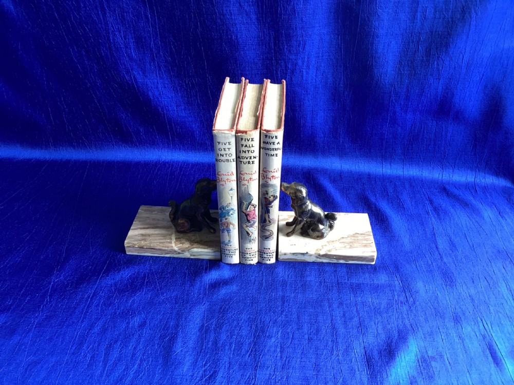 A pair of antique Art Deco bookends featuring patinated metal spaniel dogs sitting atop rectangular veined marble bases. View VIII