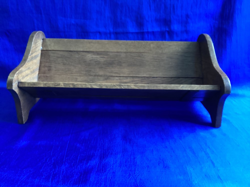 An Edwardian medium brown oak book slide featuring shaped end supports and an adjustable sliding base board. View II