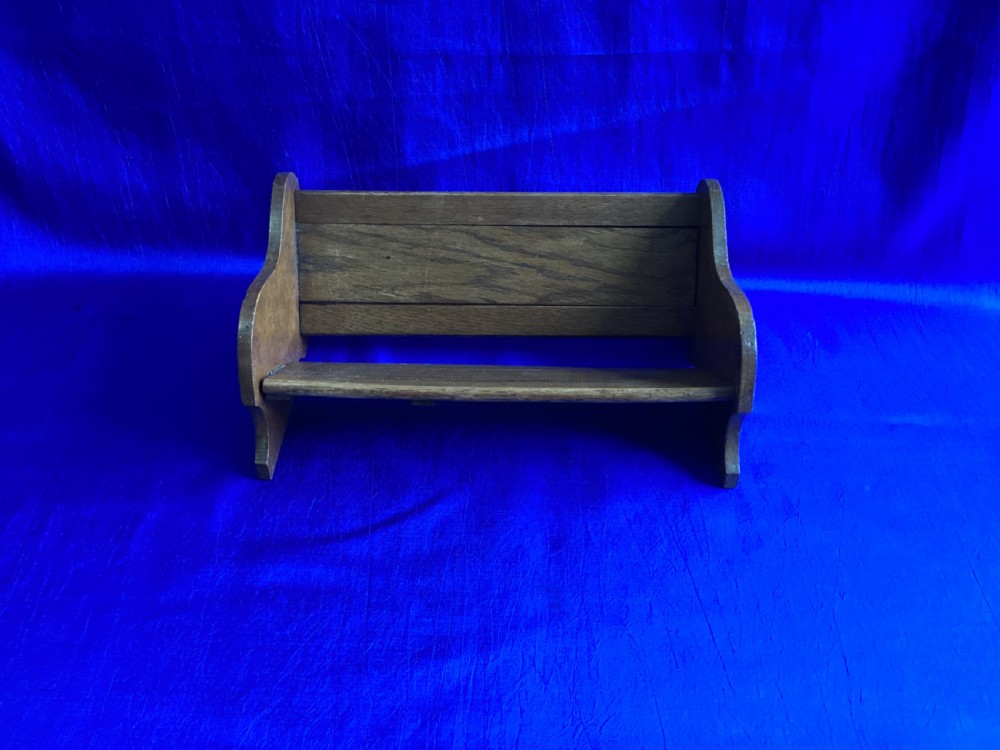 An antique oak extending book slide with shaped side panels on a blue background.