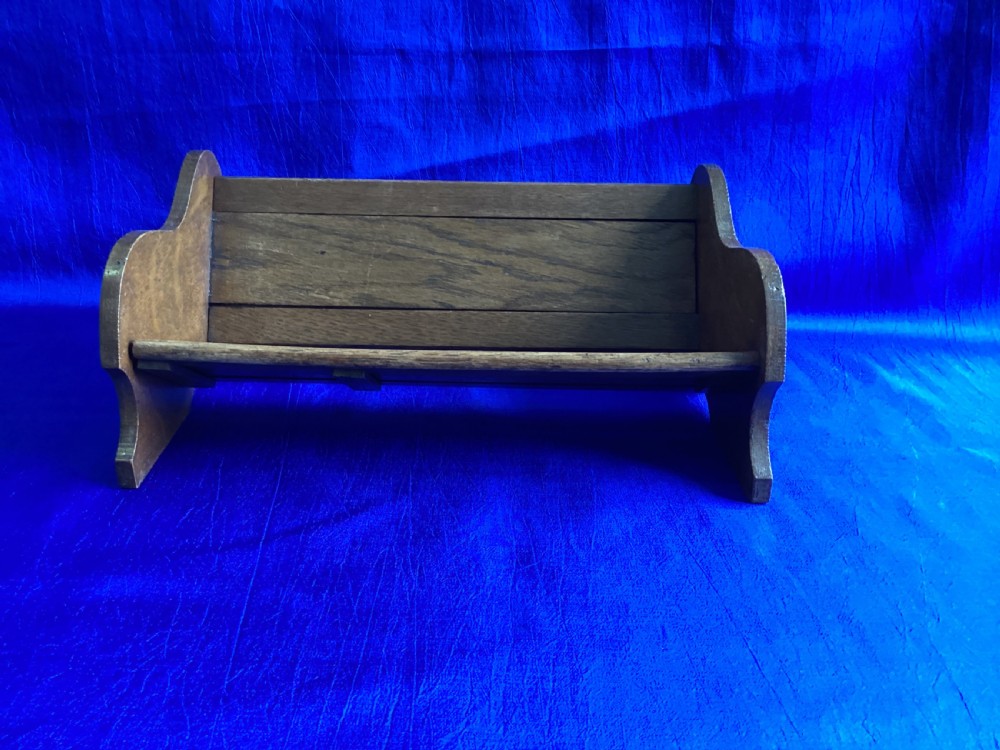 An antique oak extending book slide with shaped side panels on a blue background. View II
