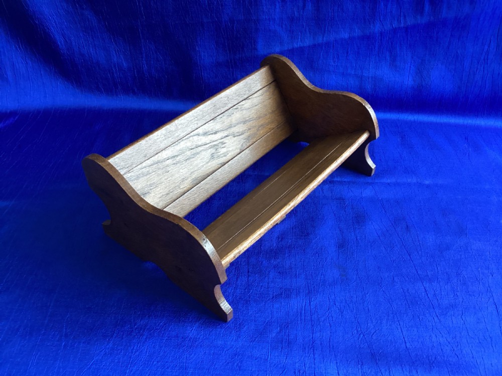 An antique oak extending book slide with shaped side panels on a blue background. View III