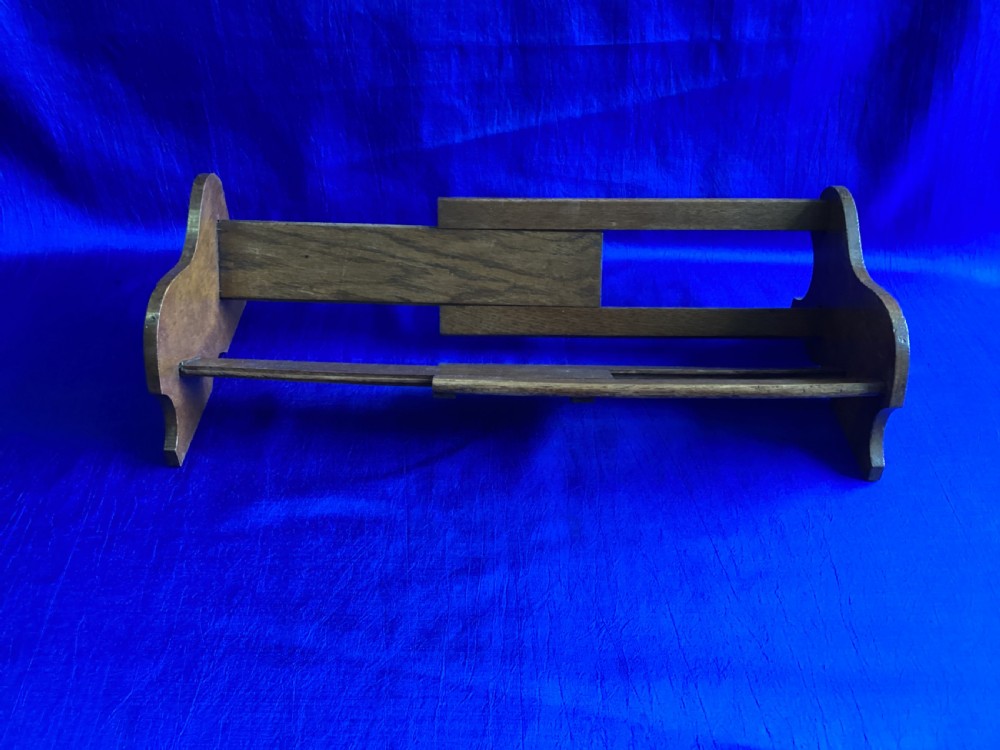 An antique oak extending book slide with shaped side panels on a blue background. View V