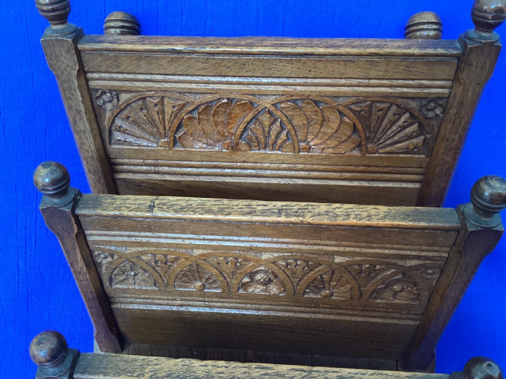 A carved oak desk letter rack featuring three tiered compartments, turned corner finials, and arched decorative carving. View VI