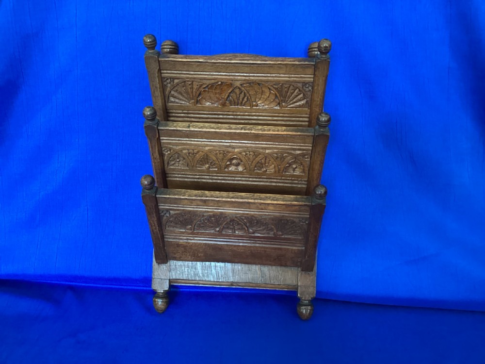 A carved oak desk letter rack featuring three tiered compartments, turned corner finials, and arched decorative carving. View VII