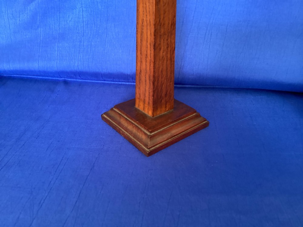 A pair of Edwardian Arts and Crafts tall oak candlesticks featuring square tapered shafts, stepped plinth bases, and brass nozzle inserts. View III