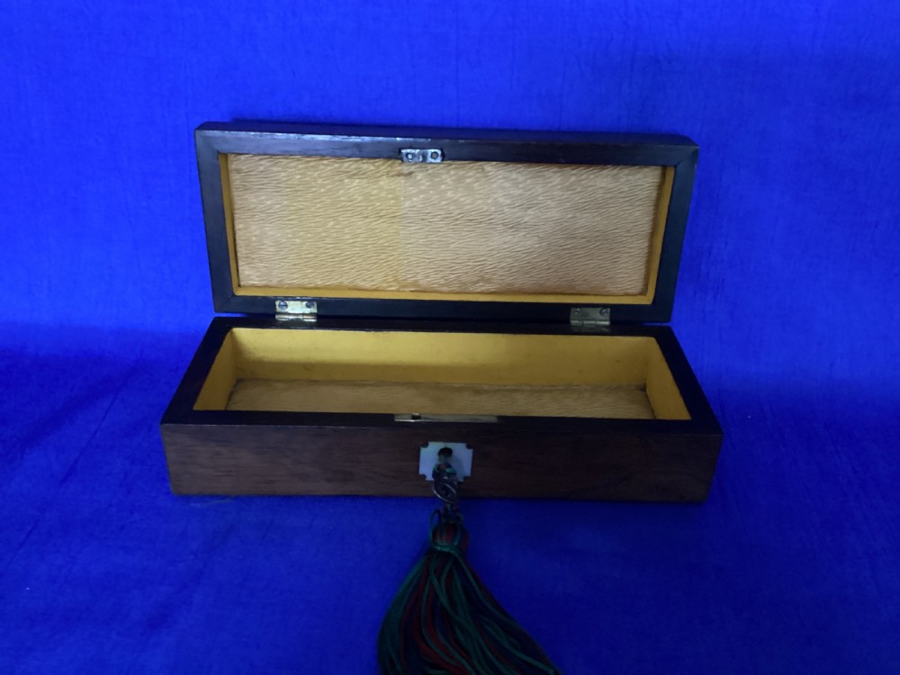 A rectangular Victorian dark rosewood glove box with a mother-of-pearl cartouche inlay on the lid and a matching keyhole escutcheon on the front. View II