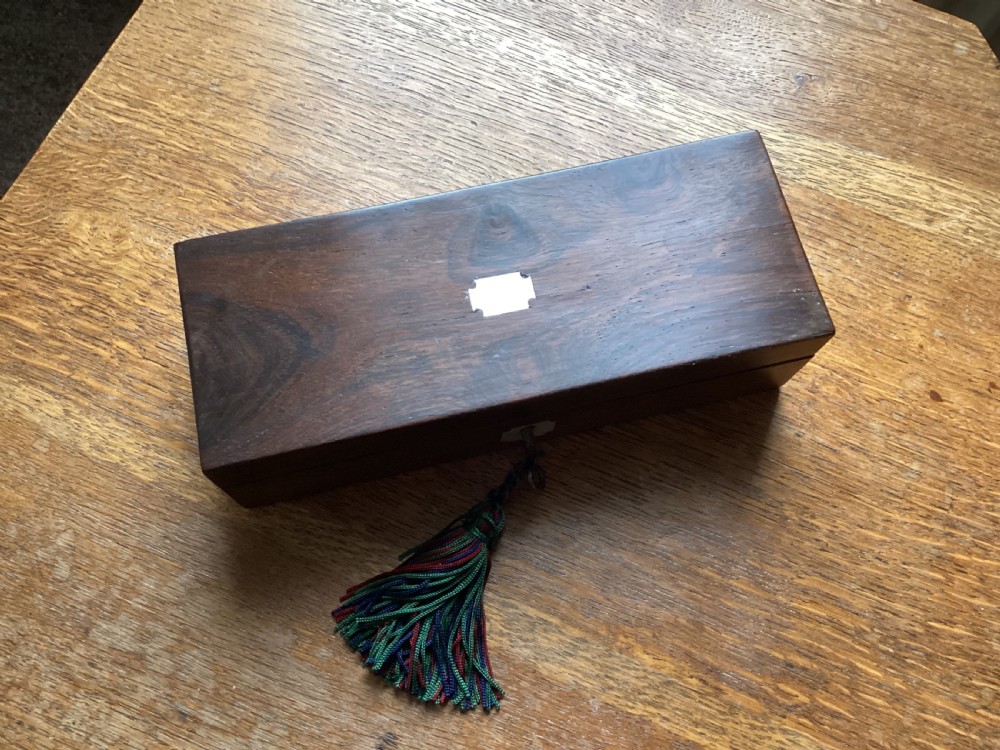A rectangular Victorian dark rosewood glove box with a mother-of-pearl cartouche inlay on the lid and a matching keyhole escutcheon on the front. View III