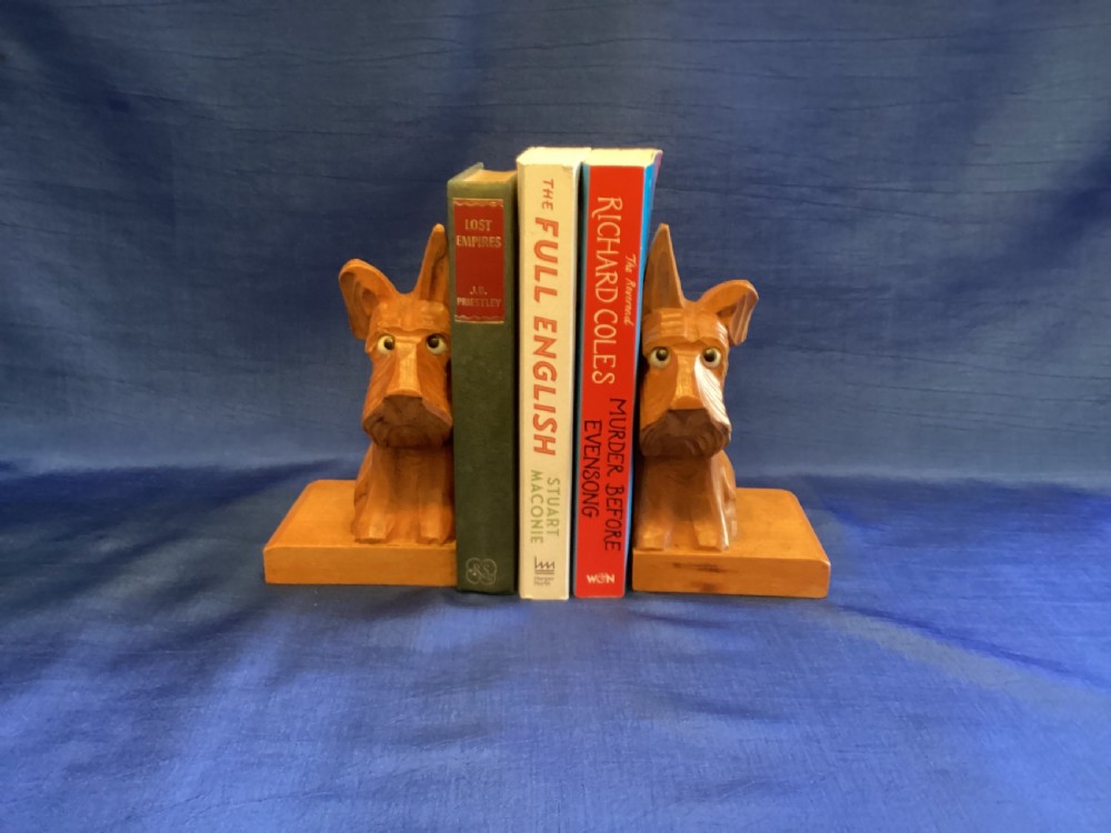 A pair of hand-carved wooden bookends shaped like Scottish Terriers with inset glass eyes on rectangular bases. View IV