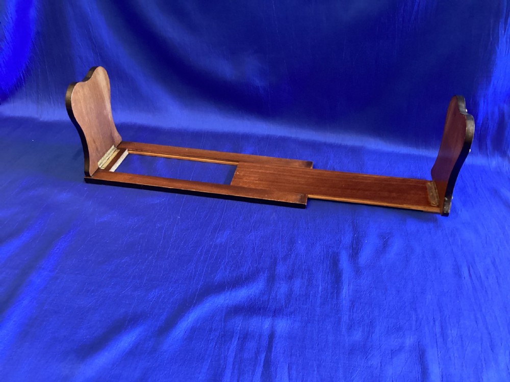 A dark mahogany extending book rest featuring decorative pierced brass scrollwork end panels with stud embellishments. View III