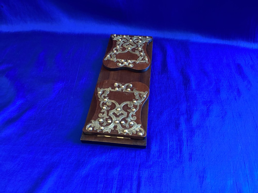 A dark mahogany extending book rest featuring decorative pierced brass scrollwork end panels with stud embellishments. View V