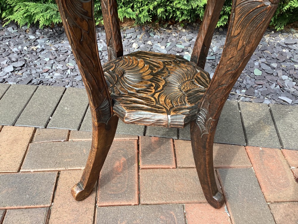 An antique dark wood octagonal side table featuring carved leaf patterns across the top surface, curved legs, and a lower tier shelf. View IV