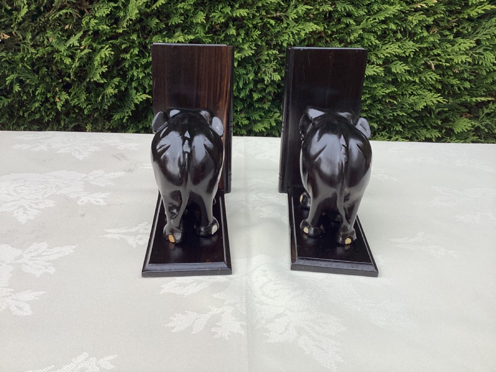 A pair of hand-carved dark coromandel wood elephant bookends featuring inlaid bone tusks and toes set on rectangular L-shaped bases. View II