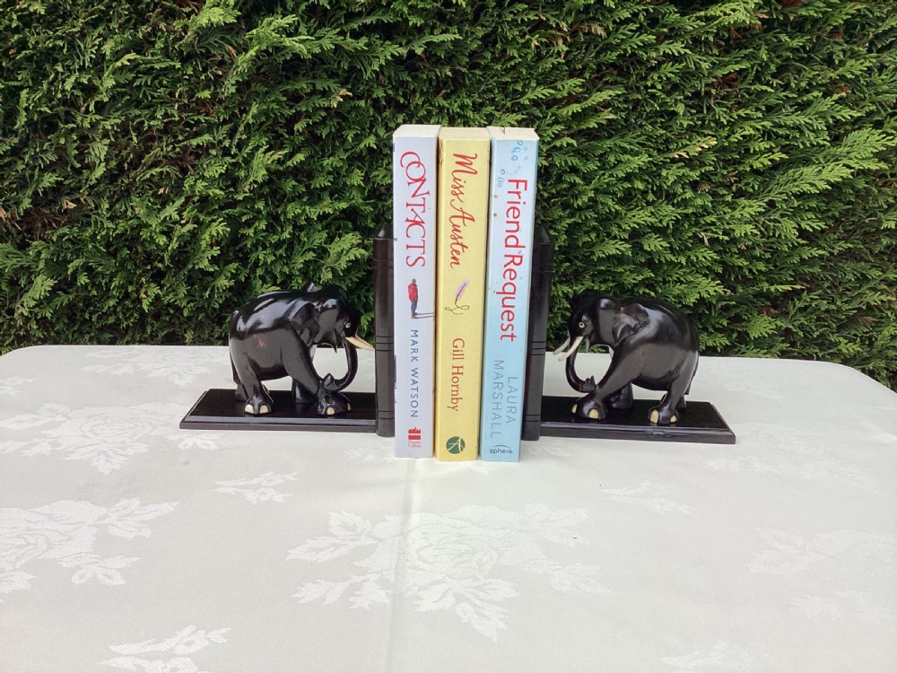 A pair of hand-carved dark coromandel wood elephant bookends featuring inlaid bone tusks and toes set on rectangular L-shaped bases. View III