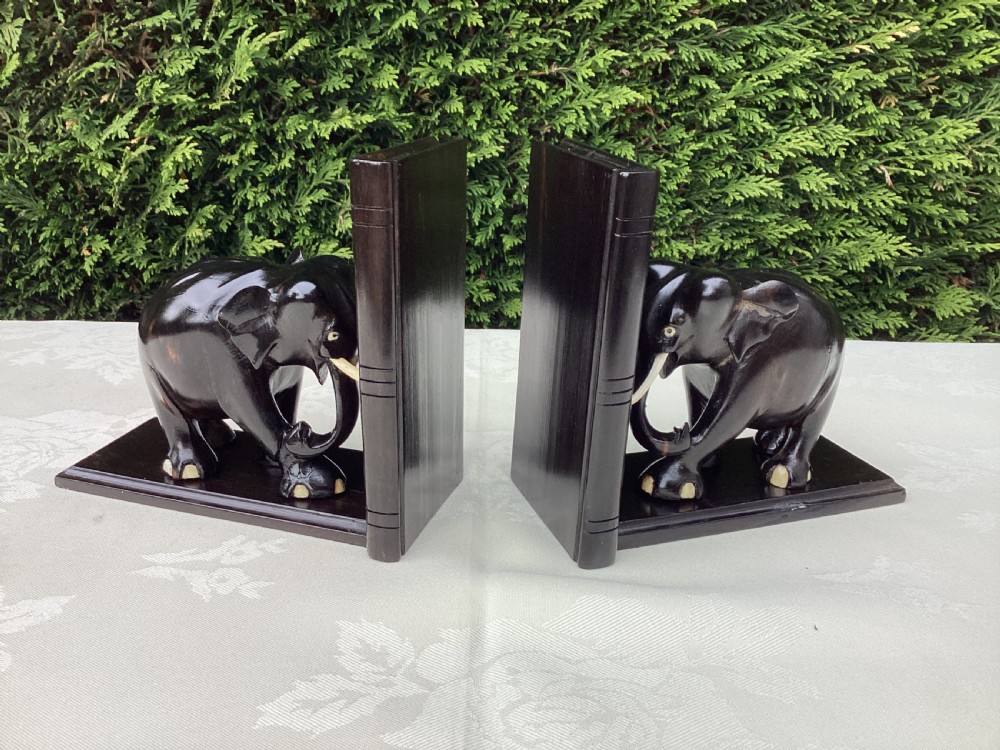 A pair of hand-carved dark coromandel wood elephant bookends featuring inlaid bone tusks and toes set on rectangular L-shaped bases. View IV