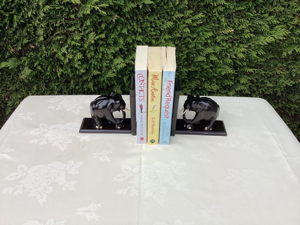A pair of hand-carved dark coromandel wood elephant bookends featuring inlaid bone tusks and toes set on rectangular L-shaped bases. View VI